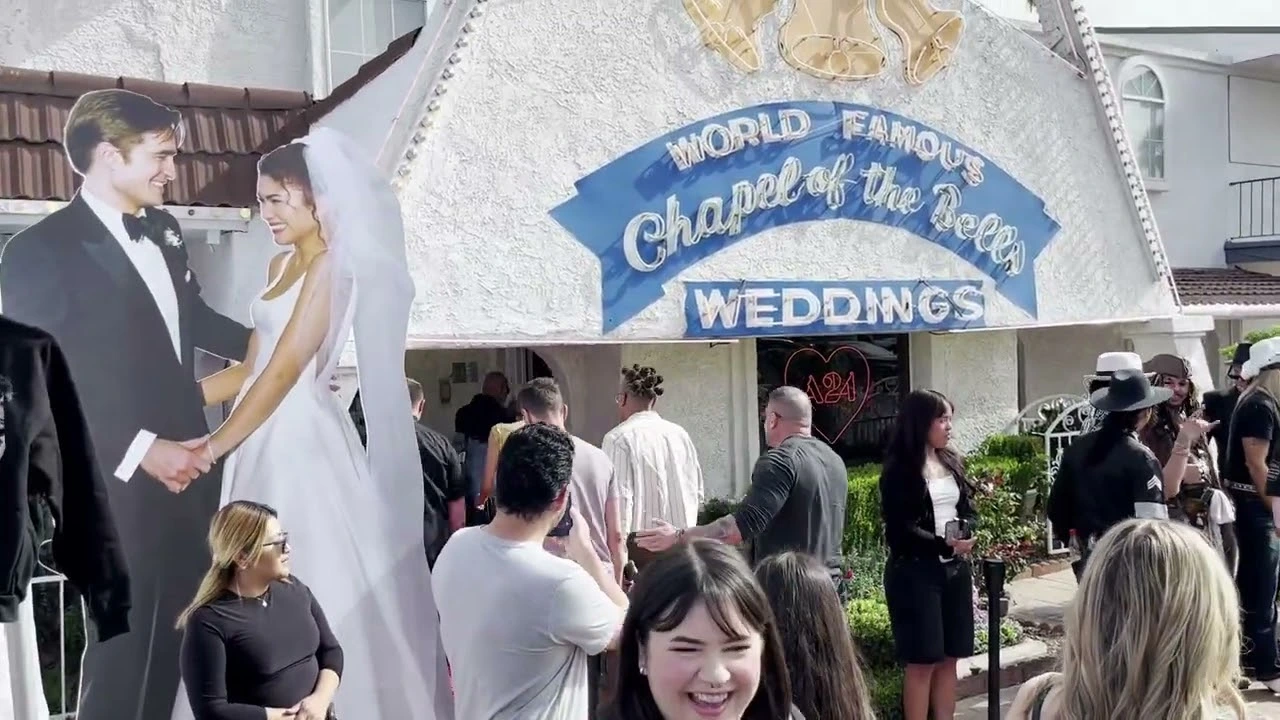 A crowd of people gathered outside of Chapel of the Bells in Las Vegas, reacting to a celebrity that just walked by.