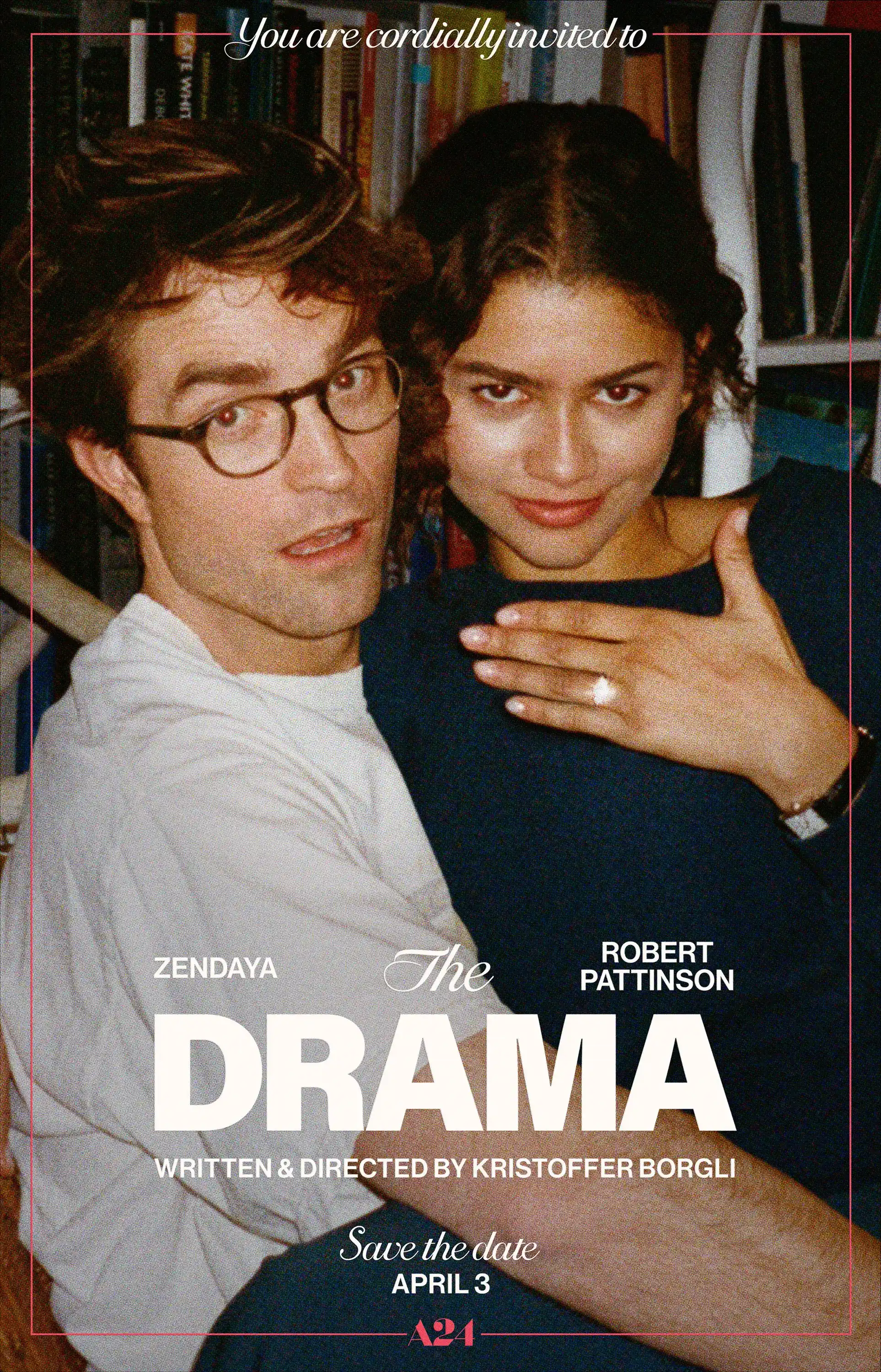Robert Pattinson and Zendaya sitting together. Zendaya holding up her hand showing an engagement ring on it.