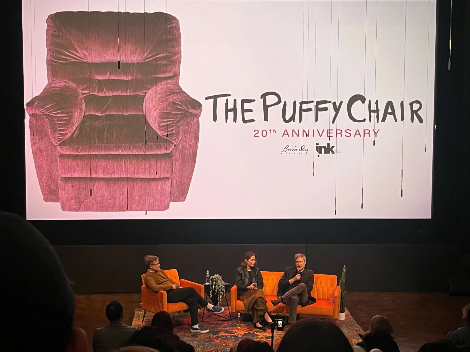Katie Aselton and Mark Duplass sitting on a couch in front of the movie screen, answering question.